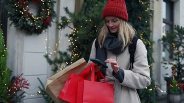 Alışveriş merkezinin yakınındaki caddede kırmızı bayram hediyelerini tutan kadınların el resimleri kullanılmış telefon paketleri. Perakende satış konsepti. Alışverişçi. Satışlar. Alışveriş Merkezi. Siber Pazartesi. Kara Cuma.