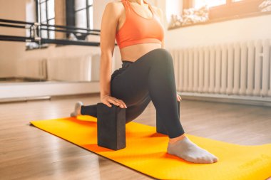 Güneşli bir günde yoga minderinin üstünde yoga bloklarıyla yoga yapan güzel, genç ve formda bir kadın yoga egzersizi.