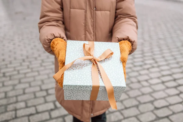 Happy young attractive woman with present gift boxes in hands after Christmas shopping in mall. Cheerful beautiful girl hold shopping bags and present boxes in hands. Winter holidays sale