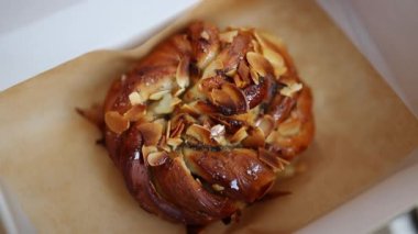 Traditional sweet swedish homemade puff pastry cinnamon rolls with almonds placed in paper box