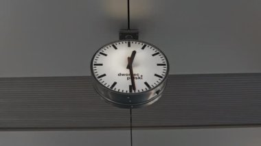 Public clock in railway station at the hanging with roof of subway central train station. It is clock for watch time waiting public travel and transportation metro train. High quality FullHD footage