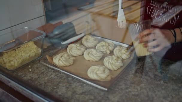Female Hand Greasing Cinnamon Rolls Yolk Homemade Pastry Baking Sheet — Stockvideo