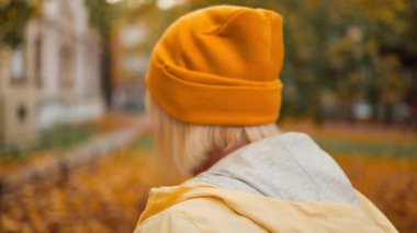 Fall. Cheerful caucasian mature blonde woman smile relaxing resting walking in city park forest alone outdoors. High quality FullHD footage