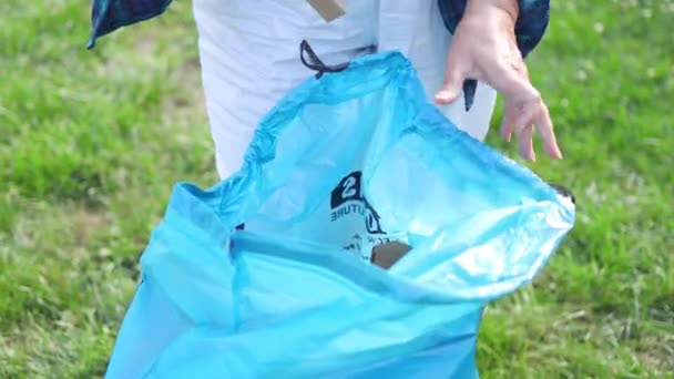 女人把一个蓝色的塑料袋 回收和废物分类的概念 — 图库视频影像