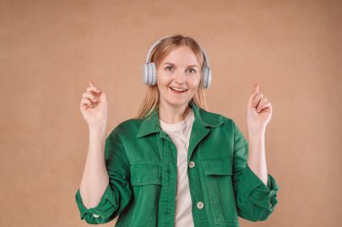 Surprised tender bride young woman 20s student with headphones in stylish clothes spreading hands keeping mouth open isolated on background studio portrait. 