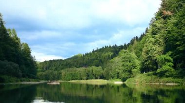 Famous Three Crowns or Trzy Korony mountain peak in Poland , Pieniny National Park. Time lapse footage with moving clouds and rafting and kayaking in river Dunajec. Tourist and ecosystem. Summer day.