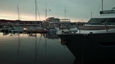 View of boats and luxure yachts in dock at sunset on a calm lake in summer in Sopot, Poland. Colorful landscape with sailboats and motorboats in sea. 