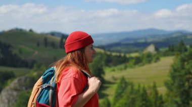 4k Young woman in orange jacket stand up on top of mountain, happy and drunk on life, youth and happiness. Watching the sunset with beautiful landscape. 