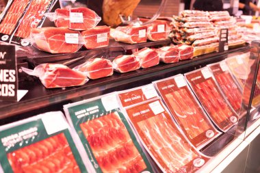 İspanya, BARCELONA, 14 Ekim 2022 - İspanyol satıcı Barcelona, İspanya 'daki La Boqueria Market' te iberico ve serrano jamon satıyor. Yüksek kalite fotoğraf