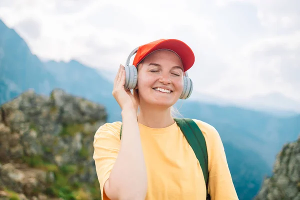 耳机里的女人听着大自然和高山的音乐 金发碧眼的女游客散步后放松一下 享受一下旅程 复制一下空间 — 图库照片