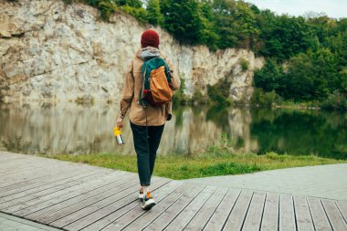 Güzel, genç ve rahat bir turist kadın yaz mevsiminde dağ gölünde meditasyon yaparken doğanın tadını çıkarıyor. Yüksek kalite fotoğraf