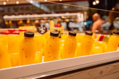 Taze meyve ve sebze suyu şişelerde, markette buzla soğutuluyor. Yemek ve içecek fotoğrafı. Yakın çekim ve seçici odaklanma