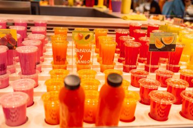 Taze meyve ve sebze suyu şişelerde, markette buzla soğutuluyor. Yemek ve içecek fotoğrafı. Yakın çekim ve seçici odaklanma