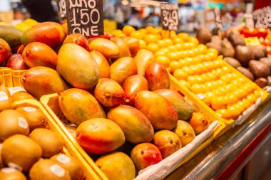 Parlak ve lezzetli mango ve diğer egzotik meyveler İspanya 'daki Barselona pazarının tezgahında. Yüksek kalite fotoğraf