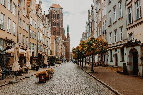 Gdansk, Polonya - 30 Ekim 2022: Eski Gdansk kasabasında sabah güneşinde Aziz Mary Katedrali ile sokak manzarası. Yüksek kalite fotoğraf