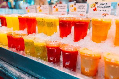 Renkli tropikal meyve suyu, market tezgahında buzlu taze soğuk içecekler, yakın plan fotoğraf. Yüksek kalite fotoğraf