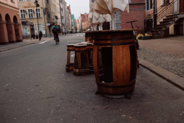 Polonya 'nın Gdansk kentindeki antik bir bakir taş duvarın önünde iki bar taburesi bulunan eski bir şarap fıçısı. Yüksek kalite fotoğraf