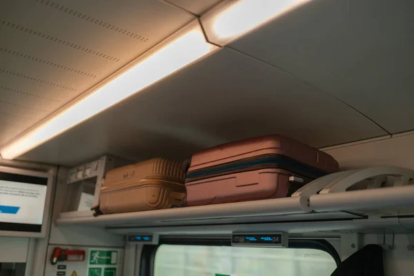 Suitcase on luggage rack in a fast modern train.
