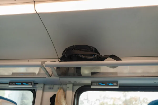 火车架子上的黑色旅游背包 旅行概念 公车上货架上的行李 高质量的照片 — 图库照片