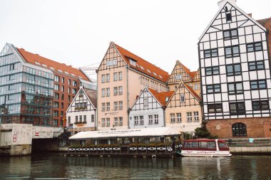 Gdansk, Polonya - 11 Kasım 2022: Arkadaki sabah güneşinin ışınlarında antik binalar ve restoranlar. Yüksek kalite fotoğraf