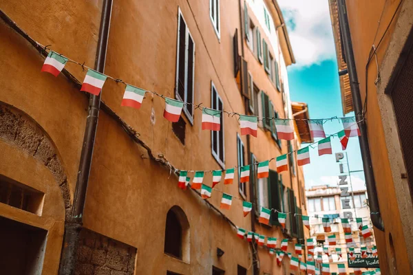 Holiday in the Italian city of streets with Italian flags and ancient buildings. Pisa, Italy. High quality photo