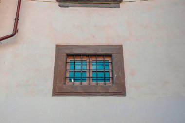 Eski bir tuğla binada, üzerinde paslı parmaklıklar olan bir pencere, yakın plan. Yüksek kalite fotoğraf