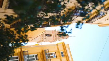 Tüm ağaçların arkasındaki eski kilise. İspanya şehirlerindeki tipik manzaralar ve otantik Katalanca caddeler. 