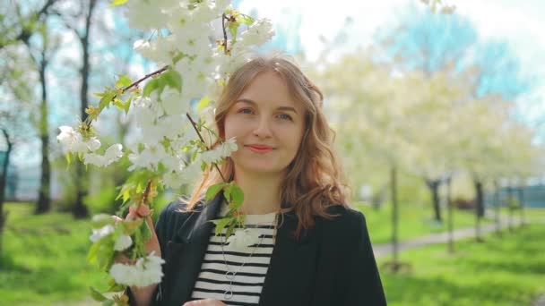 Jovem Mulher Atraente Sorrindo Apreciando Natureza Tocando Árvore Sakura Branca — Vídeo de Stock