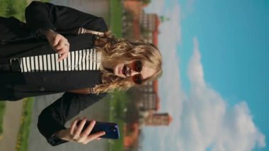 Polonya 'nın Krakow şehrindeki ünlü Wawel şatosunun önünde şık kıyafetler ve güneş gözlükleriyle selfie çeken genç, mutlu sarışın kadın turist. Yüksek kaliteli FullHD görüntüler