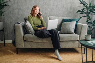 Yapma çağrısı oturma odasında telefonla konuşan bin yıllık kadın hücre gülümseyen hoş telefon sohbet, telefonda evde, neşeli genç kız mutlu genç kadın arayan sahiptir. 