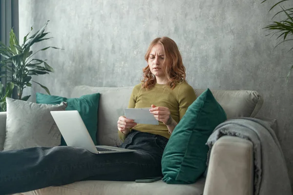 Elinde kağıtlar tutan, aile bütçesini hesaplayan, oğluna yeni bisiklet almak için para biriktirmeye çalışan, stresli ve yoğun görünümlü genç bir kadın. Yüksek kalite fotoğraf