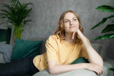 Rahat, dingin, genç bir kadın yorgunluk hissediyor rahat koltukta uzanmış, evinde dinleniyor, mutlu, sakin bayan rüyası rahat, rahat, rahat, modern oturma odasında temiz hava soluyor.