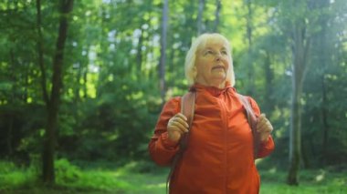 Sırt çantalı turist kadın yaprak döken ormanda yürüyor. Yeşil Vadi 'de aktif bir yetişkin yürüyüşü. Gezgin şehvet ve manzaranın tadını çıkar. Kadın yürüyüşçü vahşi hayatı keşfediyor. Yüksek kaliteli FullHD görüntüler