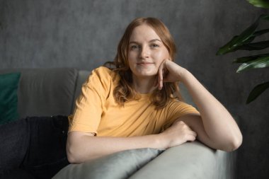 Rahat, dingin, genç bir kadın yorgunluk hissediyor rahat koltukta uzanmış, evinde dinleniyor, mutlu, sakin bayan rüyası rahat, rahat, rahat, modern oturma odasında temiz hava soluyor.