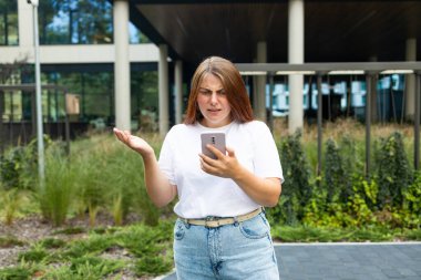 Mutsuz bir kadın sokakta akıllı telefonları kontrol ediyor. Yüksek kalite fotoğraf