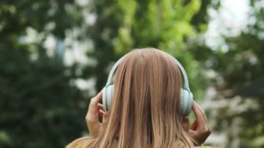 Peaceful blonde woman in modern wireless headphones relax listening to music. Happy young girl in earphones rest, enjoy good quality sound. Stress free concept. High quality 4k footage