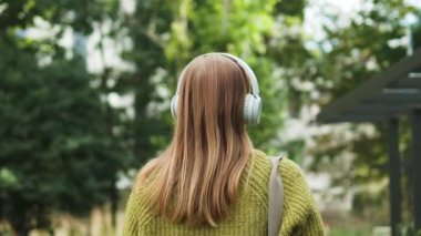 Peaceful blonde woman in modern wireless headphones relax listening to music. Happy young girl in earphones rest, enjoy good quality sound. Stress free concept. High quality 4k footage