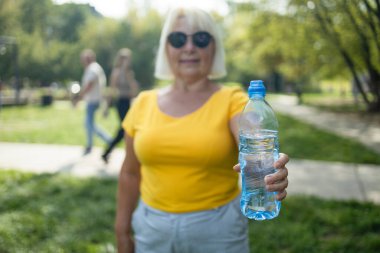 Açık havada egzersiz yaptıktan sonra poz veren mutlu, aktif, güzel bir son sınıf kadınının portresi. Yüksek kalite fotoğraf