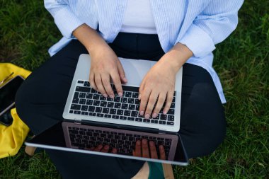 Dizüstü bilgisayar kullanan genç bir kadın. Dışarıdaki bir kafede dizüstü bilgisayarda çalışan bir kadın. Yüksek kalite fotoğraf