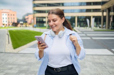 Kulaklıklı genç beyaz kadın telefonla konuşuyor, sesli sohbet ediyor ve 5 gramlık dijital bağlantıyla konuşmalar kaydediliyor.