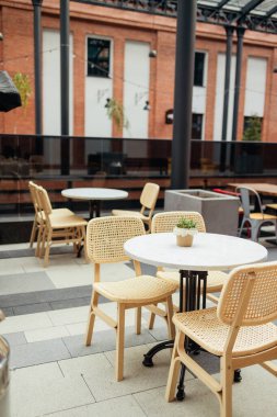 Açık kafede ya da restoranda çiçekli boş masalar. Kaldırımdaki kafede masa ve sandalyeler. Turistik bir ortam, kaldırımdaki kafe mobilyaları. Yüksek kalite fotoğraf