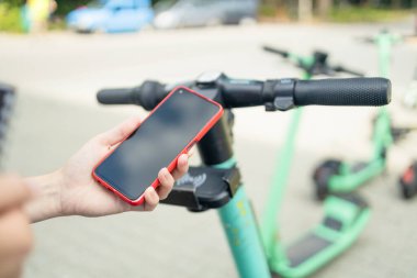 Scooter kiralama, kadın telefonlu elektrikli scooter kiralama uygulaması için kod taraması. Yüksek kalite fotoğraf