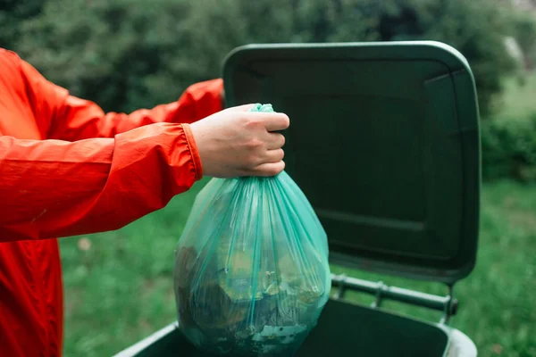 ゴミを分類する白人女性は 家の近くの屋外で小さなリサイクルビンに使用済みの紙袋を投げます 高品質の写真 — ストック写真