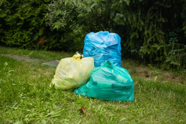 Garbage in big black plastic bags in nature, forest, at river. Spring cleaning of nature. . High quality photo
