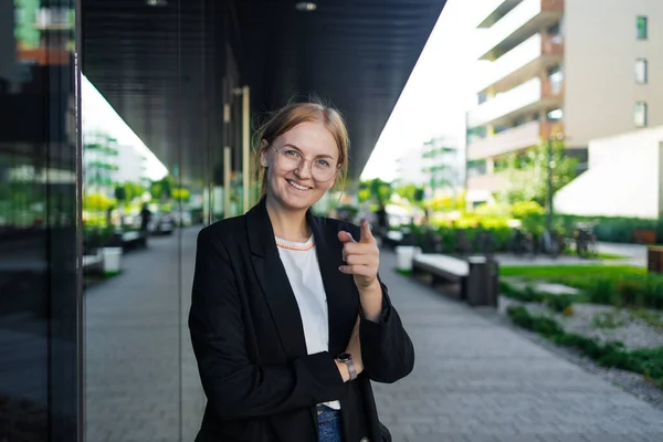 Happy business woman portrait of young female urban professional businesswoman in suit standing outside office buildings. Confident successful multicultural Caucasian woman. High quality photo