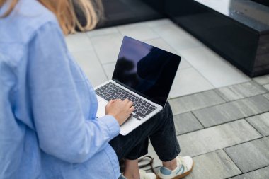 Başarılı profesyonel iş kadınının portresi. Büyük şehirde, kalabalık bir sokakta dijital laptop kullanıyor. Çevrimiçi bilgisayarda çalışmak için akıllı iş yazılımını kullanan gülümseyen bir kadın.