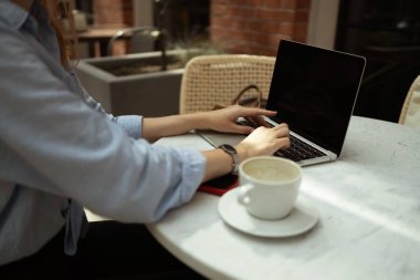 Kadın işçilerin arka planda, şehir kafesindeki modern laptopta iş arkadaşlarıyla Webcam grup toplantısı yapıyorlar. Yüksek kalite fotoğraf