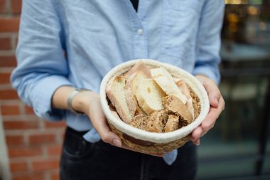 Hasır bir kaseyi taze pişmiş ekmekle tutan kadın elleri. Yüksek kalite fotoğraf
