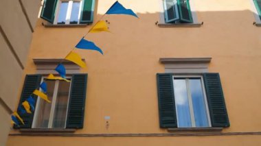 İtalya 'nın Pisa kentindeki eski bir kasabada duvarda sarmaşık büyüyen kırsal sarı geleneksel konut binasının düşük açılı görüntüsü. Yüksek kaliteli FullHD görüntüler