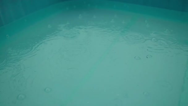 Σταγόνες Βροχής Πιτσιλίζουν Μπλε Λακκούβα Νερού Της Επιφάνειας Της Πισίνας — Αρχείο Βίντεο